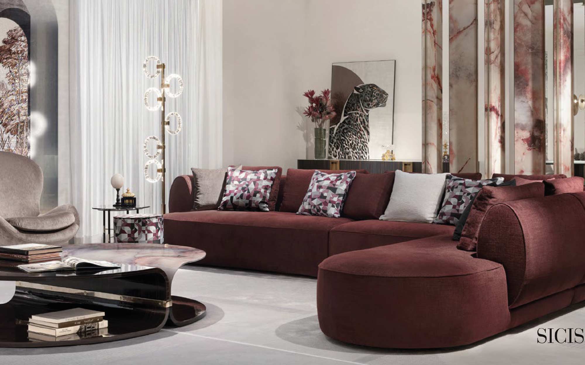 Sicis modular sofa for sophisticated and modern interiors | 101DOMUS Sicis corner sofa in burgundy fabric with decorative pillows, sculptural coffee table and contemporary accents